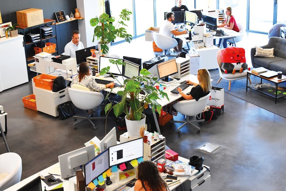 A vibrant modern office with employees collaborating at their desks.