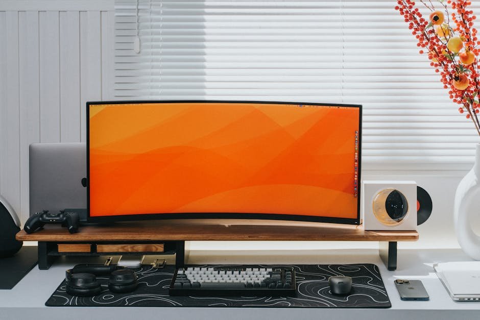 Sleek home office setup featuring a curved monitor, keyboard, and decorative elements.