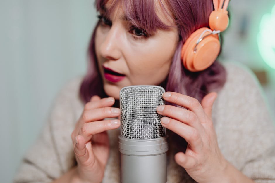 Woman recording ASMR audio with a microphone and headphones in a cozy indoor setting.